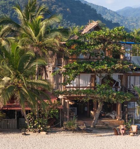 GuachacaにあるCasa Dos Almasのヤシの木が生い茂るビーチ沿いの古い建物