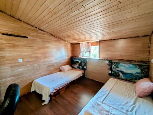 a room with two beds in a wooden cabin at Casa amazonia PT - Dois amigos in Cernache
