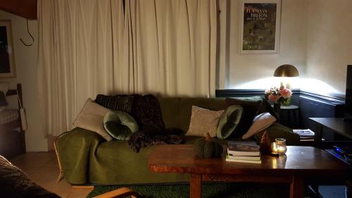 a living room with a green couch and a coffee table at Domaine La Bonne Etoile in Le Faouët