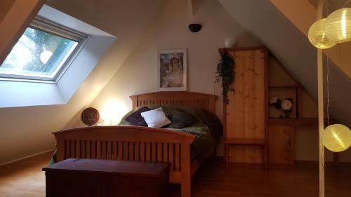 a bedroom with a wooden bed in a attic at Domaine La Bonne Etoile in Le Faouët