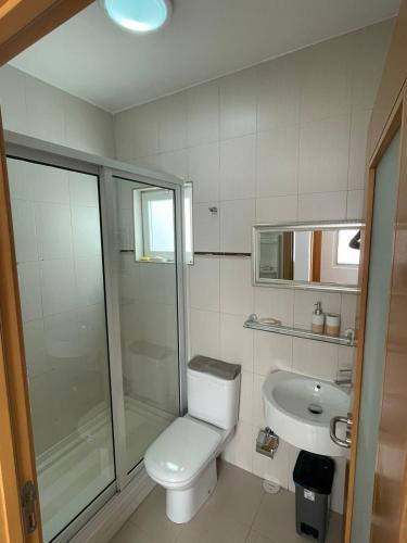 a bathroom with a toilet and a shower and a sink at Our Happy Place Prainha in Praia