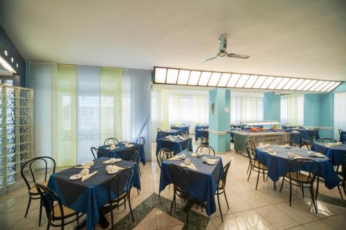 jadalnia z niebieskimi stołami i krzesłami w obiekcie Hotel Adria Mare w Rimini