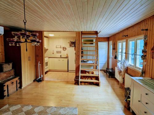 a room with a wooden ceiling and a room with a ladder at Cosy Cabin close to Lake in Ludvigsborg