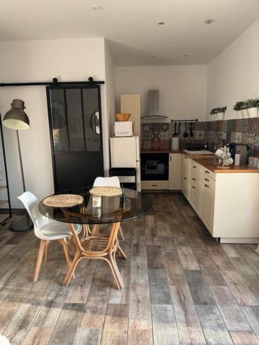 une cuisine avec une table et des chaises dans une cuisine dans l'établissement Superbe dépendance Sanary, studio jacuzzi privé, à Sanary-sur-Mer