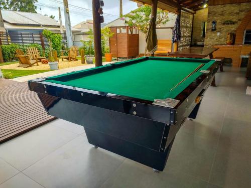 a pool table sitting inside of a house at Casa com Varanda Incrível - Sinuca, Pepolim, Piscina, Praça de Fogo - Próximo ao Parque Beto Carrero World in Barra Velha