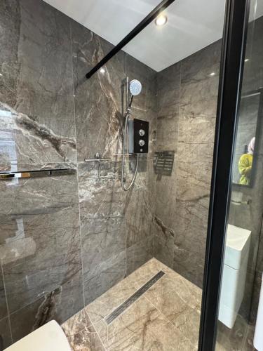 a bathroom with a shower with a glass door at Contemporary garden studio in Brighton! in Brighton & Hove