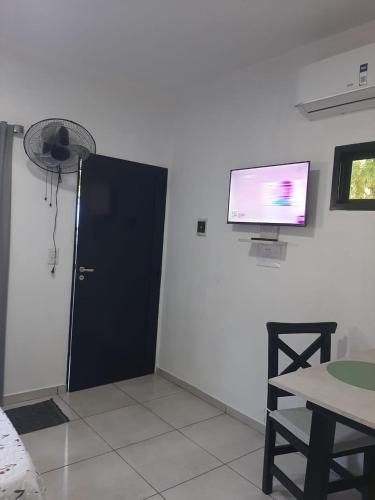 a room with a black door and a tv on the wall at OyE in Colón