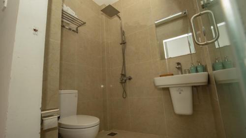 a bathroom with a shower and a toilet and a sink at Love Hotel - Khách Sạn Theo Giờ in Da Lat
