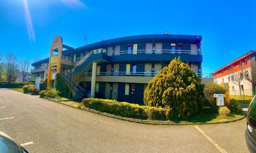 a blue building with a tree in front of it at Premiere Classe Toulouse Ouest -Blagnac Aéroport in Blagnac