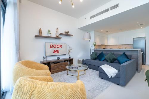 a living room with a blue couch and two chairs at Free housekeeping visits during your stay - StayShort - Bright & Elegant 2BR in Creek Harbour in Dubai