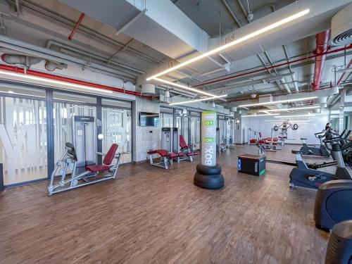 a gym with several treadmills and exercise equipment at Free housekeeping visits during your stay - StayShort - Bright & Elegant 2BR in Creek Harbour in Dubai