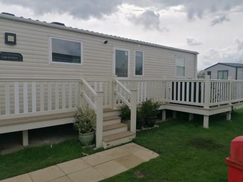 a mobile home with a white deck and stairs at Luxury Caravan with Hot tub on Tattershall lakes in Lincoln