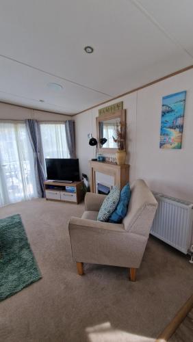 a living room with a couch and a television at Luxury Caravan with Hot tub on Tattershall lakes in Lincoln