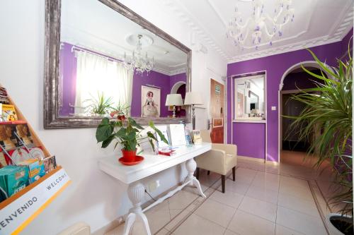 Pokój z biurkiem i fioletową ścianą w obiekcie Hostal Adriano w Madrycie