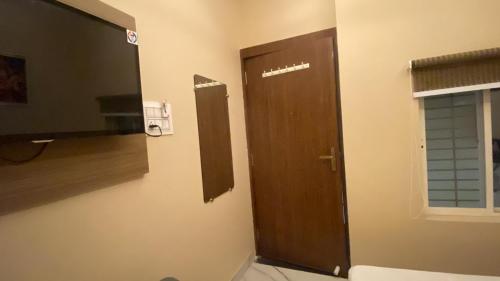 a bathroom with a wooden door and a window at Jhankar home stay in Ujjain