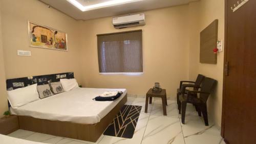 a small bedroom with a bed and a chair at Jhankar home stay in Ujjain