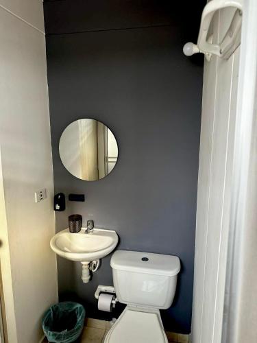 a bathroom with a white toilet and a sink at Blue House in Los Patios