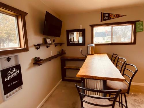 Un bar con una mesa y sillas de madera en una habitación. en Green Bay Packer Game House or Resch Expo less than 1 mile from Lambeau Field, en Green Bay
