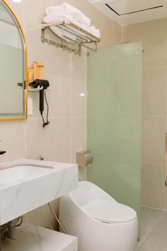 a bathroom with a toilet and a sink and a mirror at Khách sạn Ngọc Khanh in Phan Rang