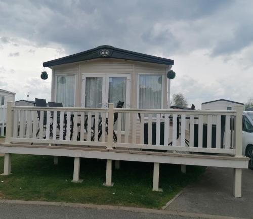 a tiny house sitting on top of a bench at Luxury Caravan with Hot tub on Tattershall lakes in Lincoln