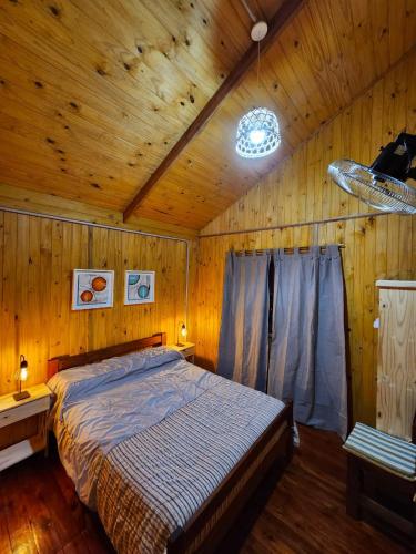 a bedroom with a bed in a wooden room at Rincon Soñado in Villa Yacanto