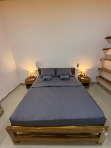 a bedroom with a large bed with two night stands at Cabaña OtraParte in Rincón
