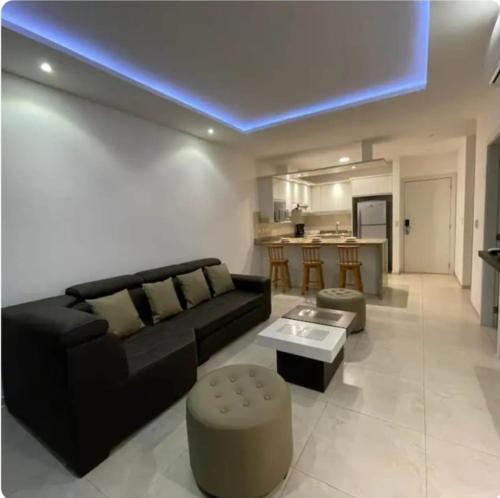 ein Wohnzimmer mit einer schwarzen Couch und einem Tisch in der Unterkunft Tonsupa, Suite Grand Diamond Beach in Tonsupa