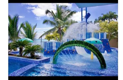 ein Pool mit Wasserrutsche in einem Resort in der Unterkunft Tonsupa, Suite Grand Diamond Beach in Tonsupa