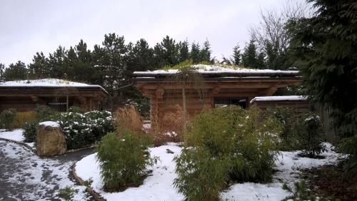 a garden with snow on the roof of a house at Les Chalets de Maramour in Chazey-sur-Ain