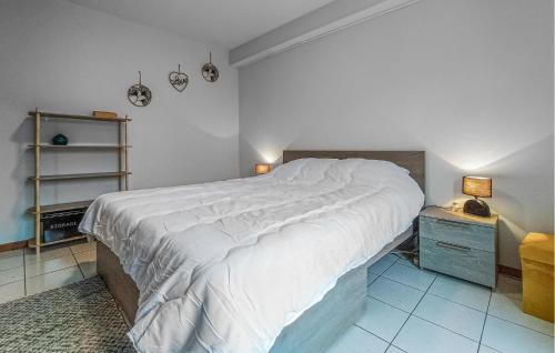 a bedroom with a large bed with white sheets at 2 Bedroom Pet Friendly Home In Treignes in Treignes
