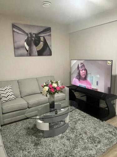 a living room with a couch and a flat screen tv at Modern suite in basement Upland in Edmonton