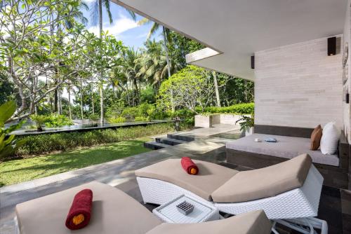 an outdoor living room with a view of the garden at Kelapa Retreat & Spa in Pulukan