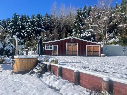 a red barn in a snow covered yard at Hanmer Glamping in Hanmer Springs