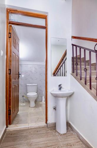 a bathroom with a sink and a toilet at Calm Haven - Cozy Home in Ruiru