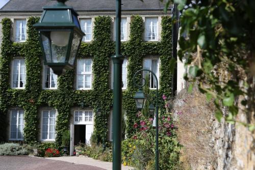 an ivy covered building with a street light in front at Hôtel d'Argouges in Bayeux