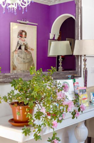 a purple room with a desk with a picture and flowers at Hostal Adriano in Madrid
