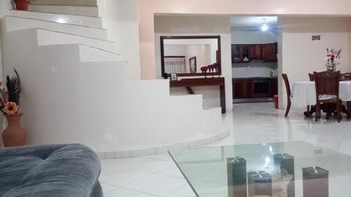 a living room with a glass table and a staircase at Kaza Mamai di Fora, o conforto da sua estadia in Calheta de São Miguel