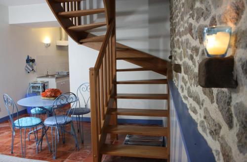 a staircase in a room with a table and chairs at Les Keriaden's in Pleudihen