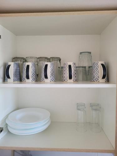 a shelf with jars and plates on it at Casa Privada El Marqués Qro in Querétaro