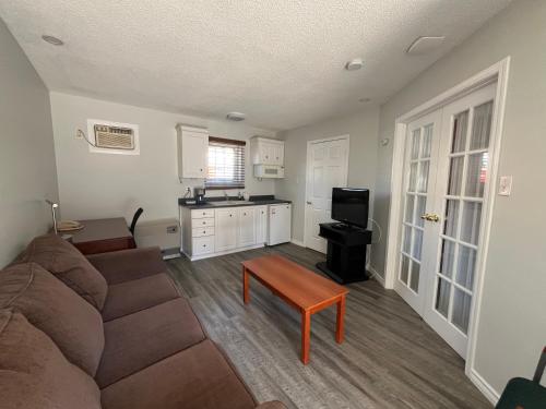 a living room with a couch and a small kitchen at Lakeshore Suites in North Bay
