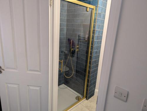 a shower with a glass door in a bathroom at Ox Lane Annexe - Harpenden in Harpenden