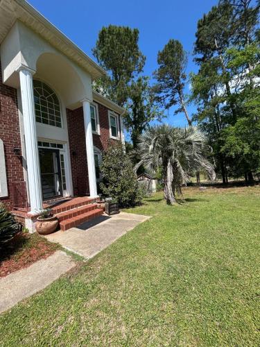 a brick house with a porch and a lawn at Evans-5bd, 4bh, AC, WiFi, Pool in Evans