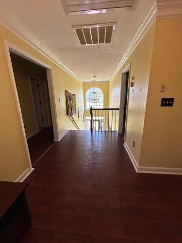 an empty living room with yellow walls and wood floors at Evans-5bd, 4bh, AC, WiFi, Pool in Evans