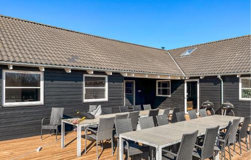 a house with a deck with a table and chairs at Stunning Home In Idestrup With Sauna in Marielyst