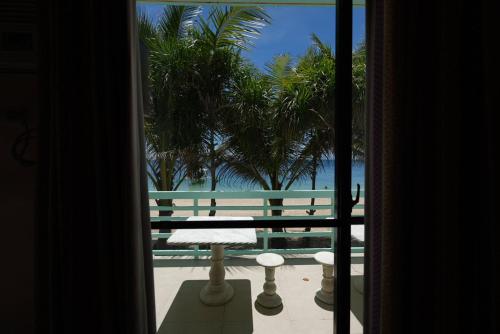 a room with a view of the ocean and palm trees at Carabao Island Beach Camp in San Jose