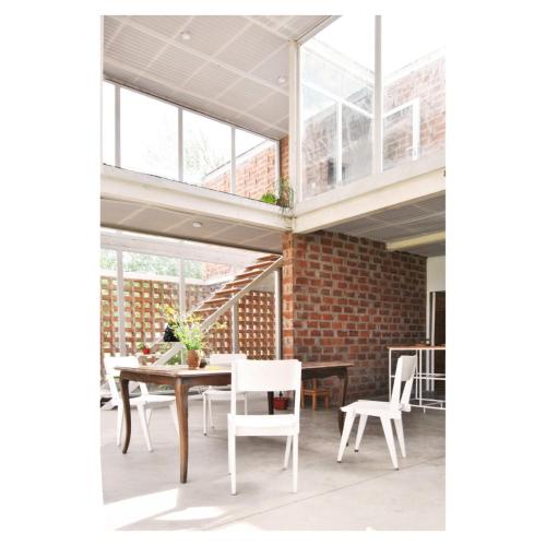 a room with a table and chairs and a brick wall at Casa PDS in La Porteña