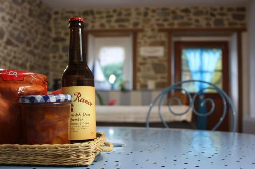 a bottle of wine and a basket of bread on a table at Les Keriaden's in Pleudihen