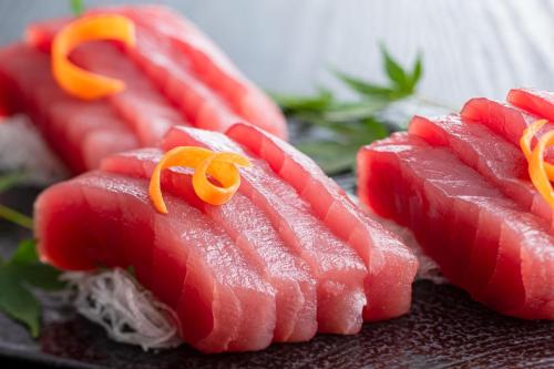 a group of red meat with orange ribbons on them at Ooedo Onsen Monogatari Yamashiro Saichoraku in Kaga