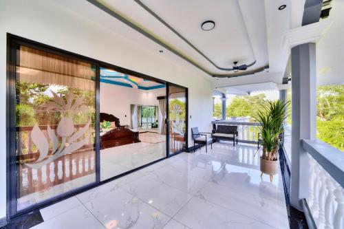 an open living room with glass doors and a living room at Samanea House Deluxe, big pool, 10min from PV in Hone Creek