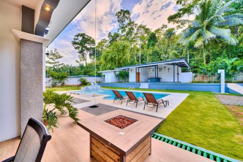 a backyard with a table and chairs and a pool at Samanea House Deluxe, big pool, 10min from PV in Hone Creek